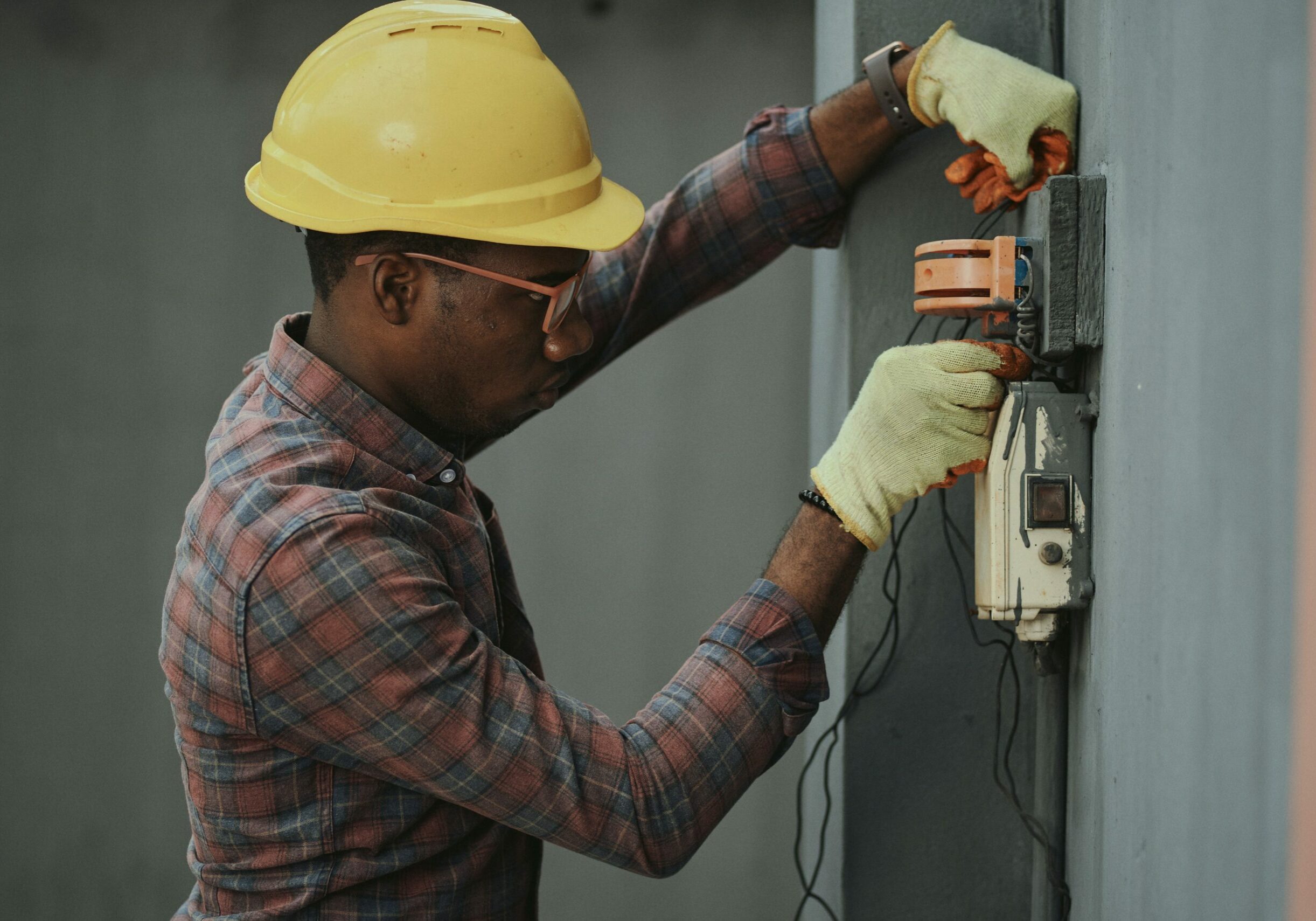 A man outside a house repairing electrical wiring.