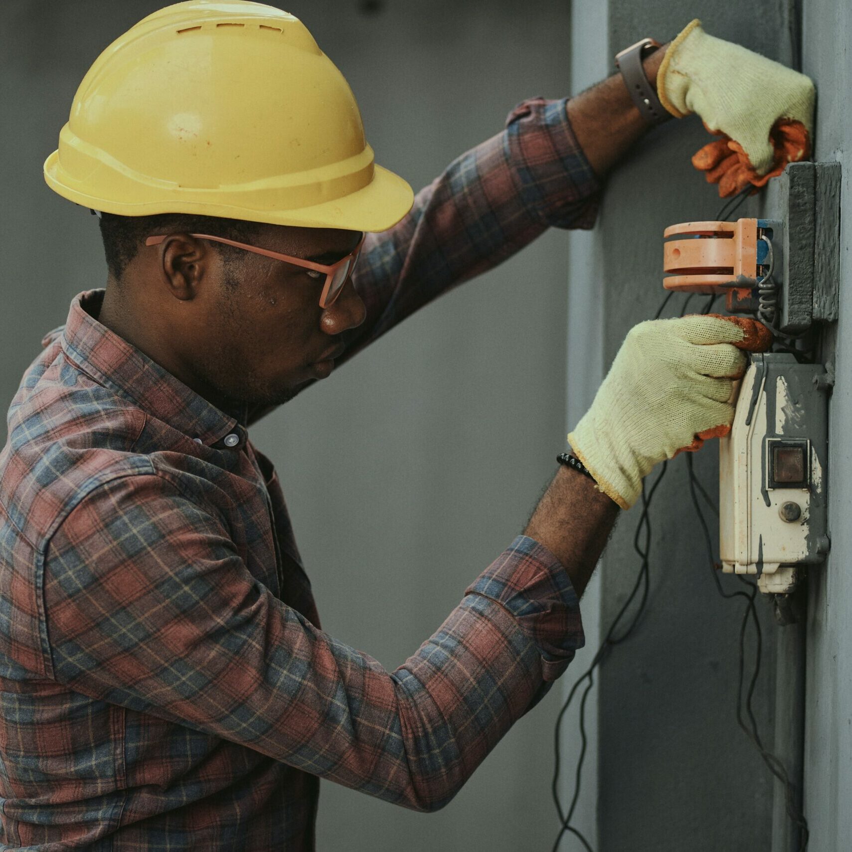 A man outside a house repairing electrical wiring.